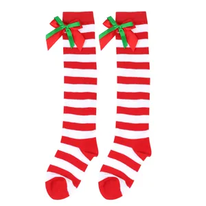 Detail of red and white striped Christmas stockings with green and red double bows