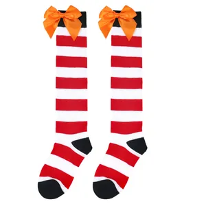 Detailed view of red and white striped Halloween knee-high socks with orange satin bows.