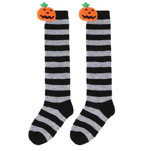 Detailed view of children's Halloween knee-high socks with plush pumpkin decorations