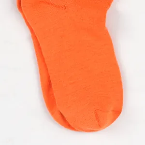 Detail view of vibrant orange knitted socks showing high-quality fabric texture.