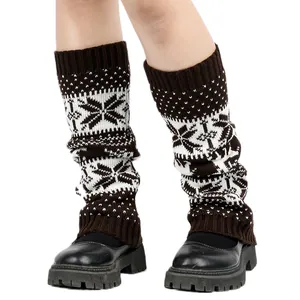 Close-up of brown knitted snowflake leg warmers with black platform shoes on white background.