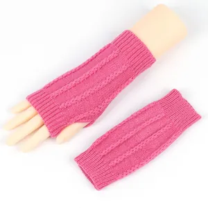 Detailansicht pinke Zopfstrick-Armstulpen ohne Finger mit Daumenloch an Modellhand.