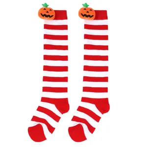 Detail of Halloween children's knee-high socks with red-white stripes and pumpkin doll