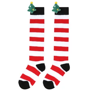 Close-up detail of children's Christmas striped over-the-knee socks with plush tree doll