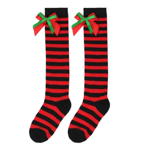 Detailed view of children's striped Christmas over-the-knee socks with red and green bows