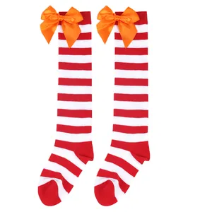 Children's red and white striped high-knee socks with large orange satin bows for Halloween.