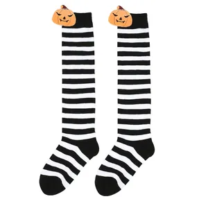 Close-up of black and white striped Halloween socks featuring plush orange pumpkin dolls.