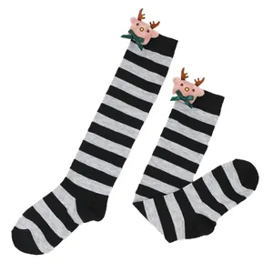 Detailed view of children's grey and black striped Christmas socks with plush reindeer doll