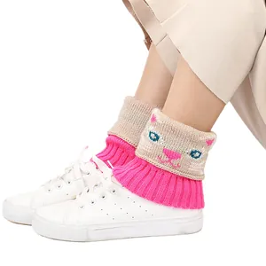 Vue détaillée des jambières en maille avec un joli motif de chat en rose et beige clair.