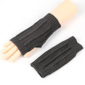 Detailansicht der dunkelgrauen fingerlosen Armstulpen mit Zopfmuster und Strickstruktur.