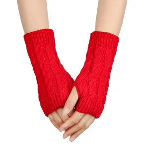 Close-up of red cable knit fingerless gloves with thumb hole for autumn and winter