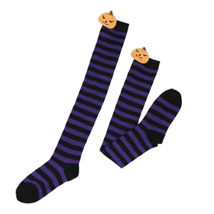 Detailed view of Halloween over-the-knee striped socks with plush pumpkin ornaments.
