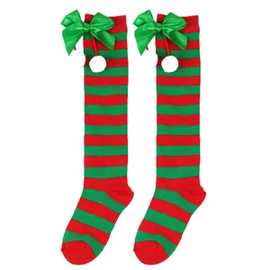 Detail of children's Christmas knee-high socks with green bows and white pompoms