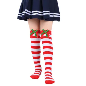 Close-up of girl's red and white striped Christmas over-the-knee socks with bows