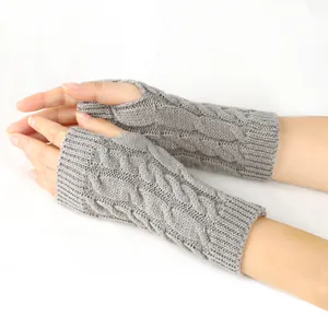 Detail view of grey cable knit fingerless gloves showing the intricate texture and fit