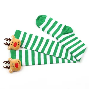 Detailed view of festive green and white striped Christmas stockings with elk decor