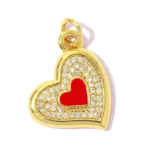 Detailed view of gold-plated heart pendant with red inlay and clear cubic zirconia stones.
