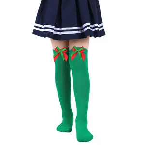Close-up detail of festive green over-the-knee girl socks with red and green bows