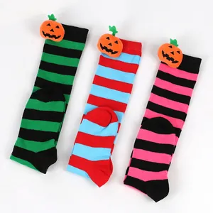 Close-up of striped Halloween knee high socks with plush pumpkin dolls for kids