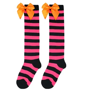 Detail of girls striped over-the-knee socks with vibrant orange satin bow for Halloween