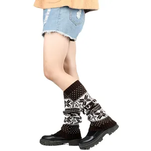 Close-up of knitted leg warmers with snowflake pattern worn with black shoes