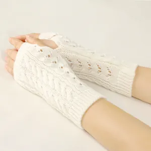 Close-up detail of white cable knit fingerless gloves with intricate lace pattern