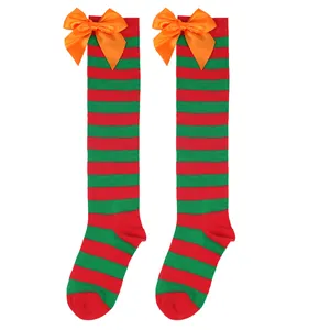 Detail view of red and green striped over-the-knee socks with large orange satin bows for girls