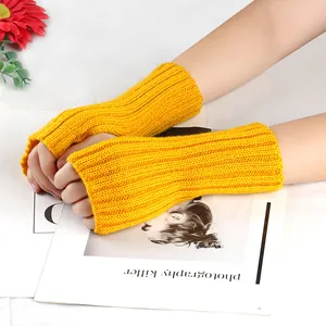 Gros plan de mitaines en tricot jaune vif portées sur les mains d'un mannequin.