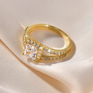 Nahaufnahme eines 14k vergoldeten Kreuzbandrings mit funkelndem quadratischem 5A-Zirkonia