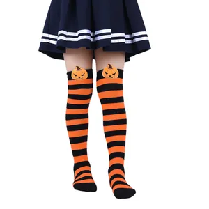 Close-up of orange and black striped Halloween socks with a cute plush pumpkin head