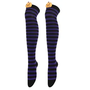 Macro view of purple and black striped over-the-knee socks with cute pumpkin plush.