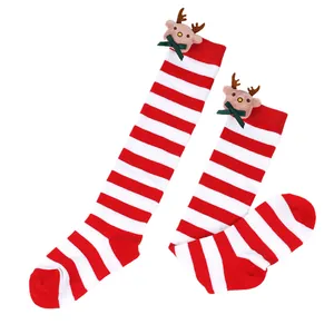 Cozy red and white striped Christmas knee-high socks for kids featuring cute plush reindeer dolls