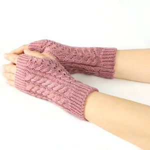 Close-up of pink cable-knit fingerless gloves with elegant hollow-out design patterns.
