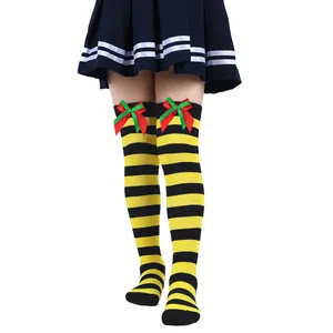 Detail view of girls' yellow and black striped over-the-knee socks with festive bows