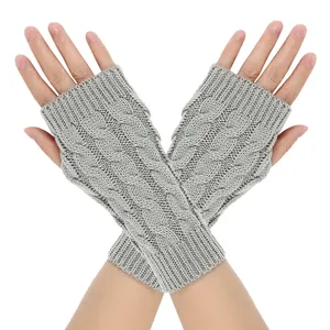 Detail view of gray cable-knit fingerless gloves with a decorative twist pattern