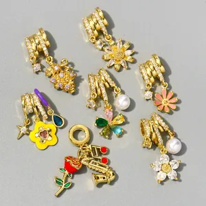 Close-up of assorted golden zircon charms featuring daisy, rose and musical notes