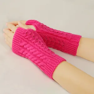 Detail of hot pink cable knit fingerless gloves with hollow-out design for winter warmth.