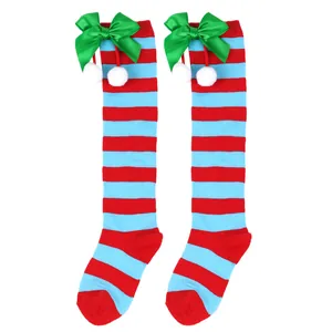 Detailed view of children's Christmas knee-high socks with green bows and white pom-poms