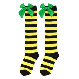 Detail view of yellow and black striped knee-high socks decorated with green satin bows.