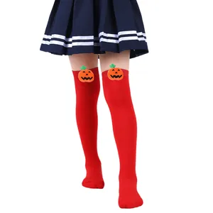 Detail view of children's red over-the-knee socks with cute 3D Halloween pumpkin dolls.