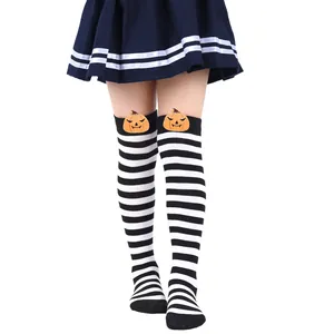 Detail of striped over-the-knee socks with plush pumpkin decorations for kids