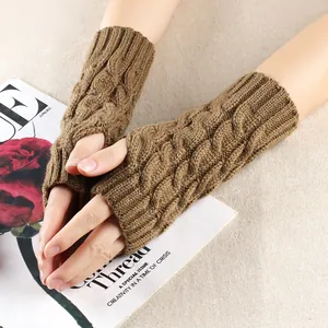 Close-up detail of brown cable knit fingerless gloves showing intricate acrylic yarn texture