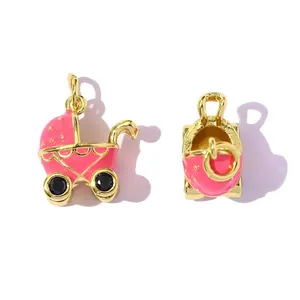 Detailed view of pink enamel baby carriage charms with gold plating and blue stones.