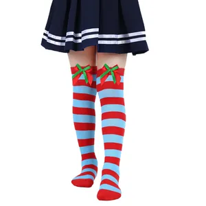 Close-up detail of girls' Christmas over-the-knee striped socks with festive bow decor