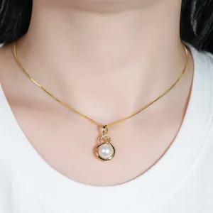 Detailaufnahme einer 14k goldgefüllten Halskette mit Perlenanhänger am Hals