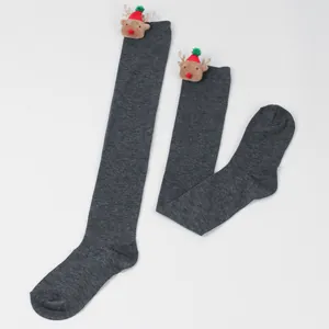Detailed close-up of grey over-the-knee socks with cute plush reindeer heads for Christmas