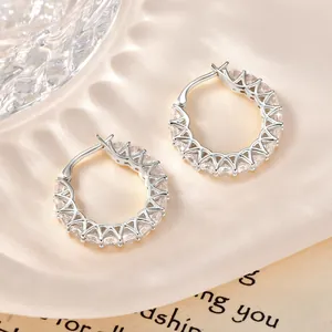 Detalle de pendientes de aro bañados en oro de 14k con circonitas en raso.