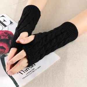 Close-up of black cable knit fingerless gloves showing texture and thumb hole
