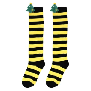Detailed view of children's striped Christmas socks with plush tree ornaments.