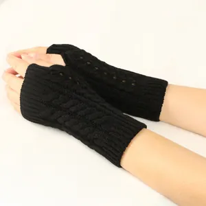 Detailed macro view of black cable knit fingerless gloves showing hollow-out texture